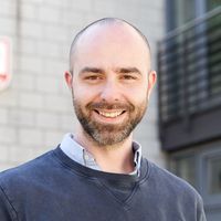 Denis Stein von Zimmer FREI! Real Estate steht lächelt vor dem Büro in Flensburg.